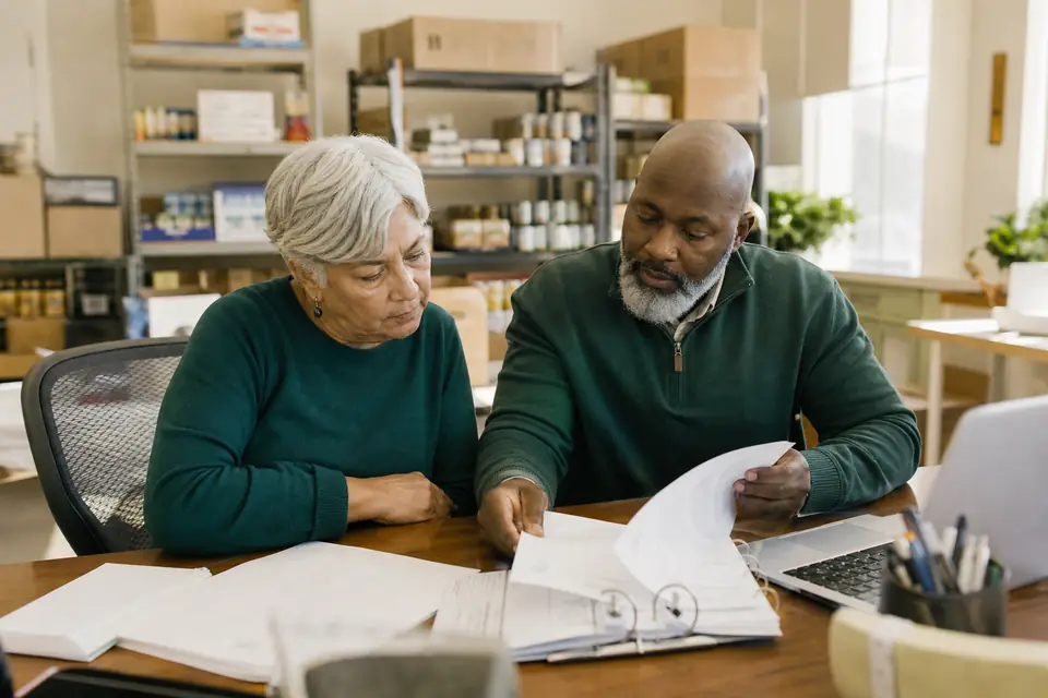 Food pantry treasurer and director reviewing financial records in a small office