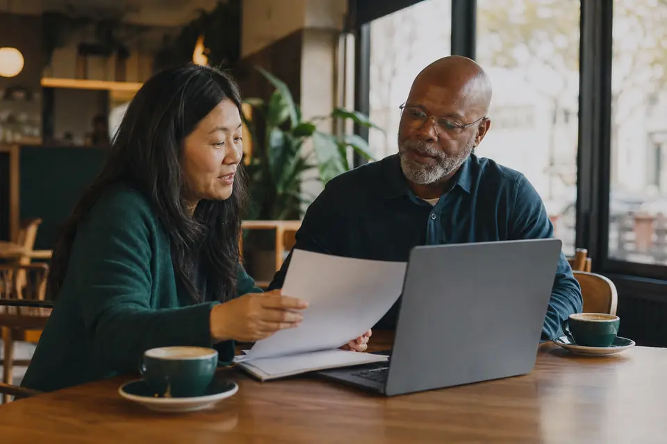 Founder and treasurer at a cafe table preparing answers with a letter and laptop